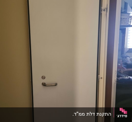 דלת לבנה עם ידית מתכת בחדר פנימי